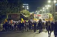 Manifestation en soirée, avec des banderoles antifscites et anti-nazis.