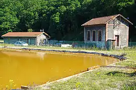 Le bassin de décantation et d'anciens bâtiments.