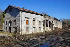 Un bâtiment industriel dont une partie est converti en habitation et l'autre resté sans toiture et sans fenêtre.