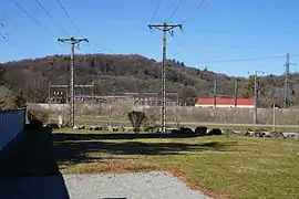 Des pylônes et des bâtiments avec une colline à l'arrière plan.