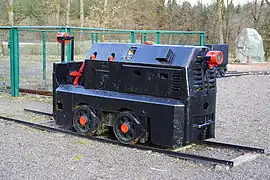 Une locomotive de mine restaurée avec des rails.