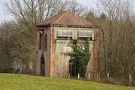 Petit bâtiment trapu davec des fenêtres en cadrées de briques dont la partie supérieur est arrondie.