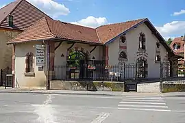 Petit bâtiment de style industriel ancien agrémenté de brique rouge.