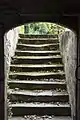 Escalier menant à la geôle médiévale. Celle-ci a été fortifiée par l'Occupant Allemand pour en faire un abri face aux bombes des Alliés.