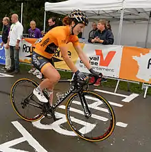 Photographie d'Elisa Longo Borgini, cycliste, en orange, vue de profil.
