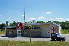 Bâtiment moderne marqué par la couleur rouge et surmonté d'une grande antenne.