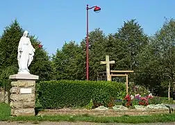 Statue de la Vierge, calvaire et fleurissement.