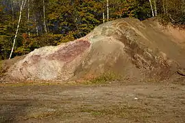 Tranche excavé laissant apparaître différents couches de roche agglomérées.