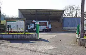 Un camion garé à côté d'un stock de bois pulvérisé.