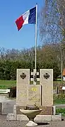 Stèle cubique et drapeau français.