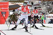 Un fondeur en pleine montée devant deux autres concurrents.