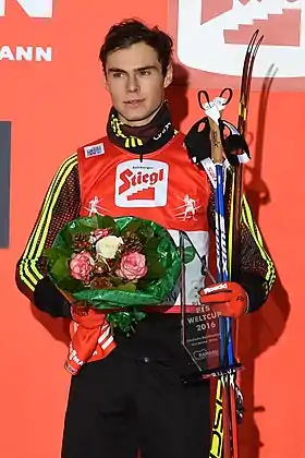 Un homme su un podium un bouquet à la main.