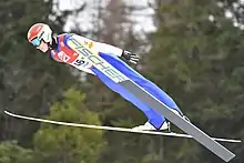 Un sauteur à ski en plein saut.