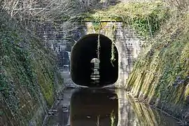 Un tunnel arrondie en pierre ou s'écoule un mince filet d'eau.