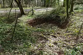 Même trou vu de plus loin entouré de piquets reliés par un câble détendu.