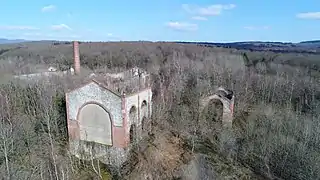 Groupe de bâtiments surmontés d'une cheminée en brique rouge.