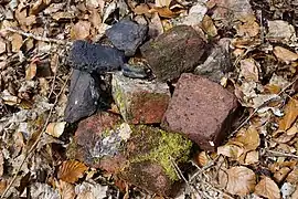 Petits fragments de pierres noires et briques rouges.