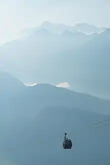 Une cabine toute petite dans le vertige d'une brume bleutée, simplement soutenue par quelques câbles.