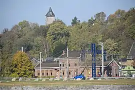 photo couleur la gare avec en arrière-plan, émergeant des arbres de la colline le sommet de l'église