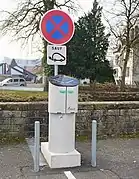 Un borne pour voiture électrique surmontée d'une panneau interdisant aux autres véhicules de stationner ou de s'arrêter.