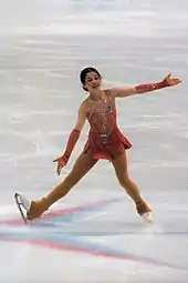 Une jeune patineuse sur glace effectue une figure artistique.