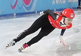 photo en couleur d'une jeune patineuse prenant un virage en plein vitesse, bien penchée