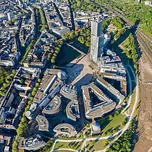 Une place centrale, d'où rayonne en demie-étoile de grands immeubles massifs, l'un d'entre-eux ressemblant à un gratte-ciel.