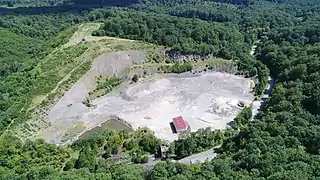 Une colline exploitée entourée de forêtes.