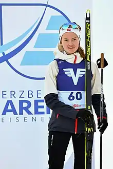 Une femme souriante sur un podium.