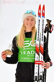 Une femme blonde, souriante avec un bonnet.