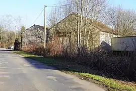 Petit bâtiment industriel en béton derrière des arbres.