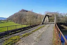 Une pont en béton et un terril en arrière-plan.