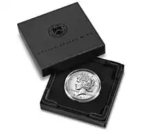 Boîte de couleur sombre contenant une pièce de monnaie. Le couvercle comprend l'inscription United States Mint et un écusson.