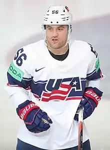 Photographie d'un joueur de hockey sur glace avec un maillot blanc.