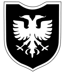 Un blason militaire représentant un aigle à deux têtes blanc sur fond noir.