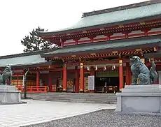 Photo couleur du bâtiment réservé au culte d'un sanctuaire shintō. Fond blanc laiteux