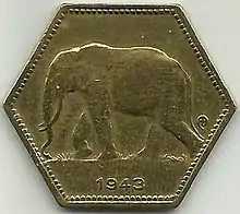 Une pièce jaune hexagonale avec le dessin d'un éléphant et la date 1943.