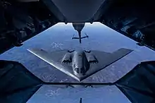 Un B-2 en vol arrivant derrière un avion ravitailleur.