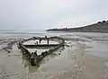 Plage de Kervijen : épave émergeant du sable à marée basse un jour d'amaigrissement de la plage.