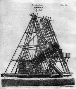 Un très grand télescope porté par un échafaudage en pyramide sort d'une maison en bois, porté par des poulies situées au sommet de la construction. Le tout est monté sur une plate-forme pivotante.