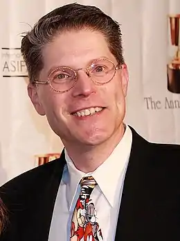 Homme blanc aux cheveux noirs coupés courts et yeux bleus.