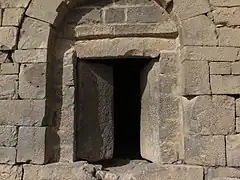  porte entrouverte aux battants en pierre