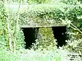 Ancien pont en dalles de schiste sur le ruisseau parallèle au Canal de Nantes à Brest au sud du pont de Kervoulédic