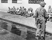 Un soldat de la 5e division indienne surveille des prisonniers de guerre japonais.