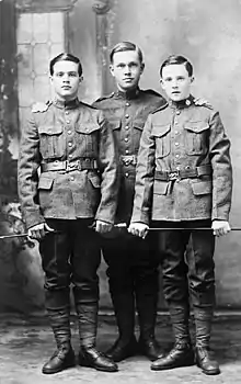 Portrait en noir et blanc de trois jeunes hommes en uniformes militaires