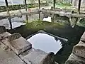 Le lavoir à impluvium de la Clarté : vue du bassin à l'intérieur du lavoir couvert.