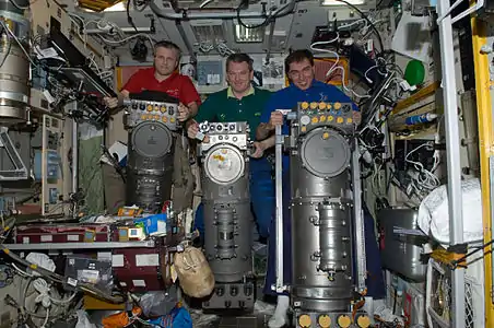 Les cosmonautes russes Andreï Borissenko (à gauche), commandant de l'expédition 28, Alexandre Samokoutïaev (au centre) et Sergeï Volkov, tous deux ingénieurs de vol, sont photographiés avec des systèmes à générateur d’oxygène Elektron russes dans le module de service Zvezda de la station spatiale internationale.