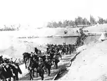 Photographie de troupes traversant un fleuve.