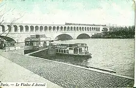 Le viaduc d'Auteuil au début du XXe siècle. Au premier plan, navire de la Compagnie des Bateaux parisiens, assurant un service de navettes fluviales.