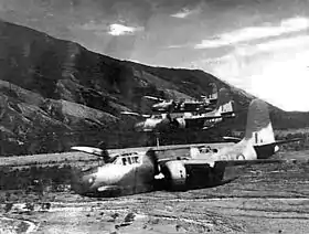 Three twin-engined military aircraft flying low above a valley